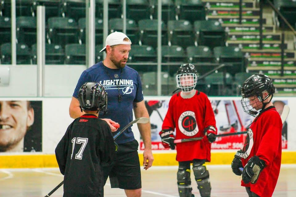 Eric Neilson coaching young players on the ice